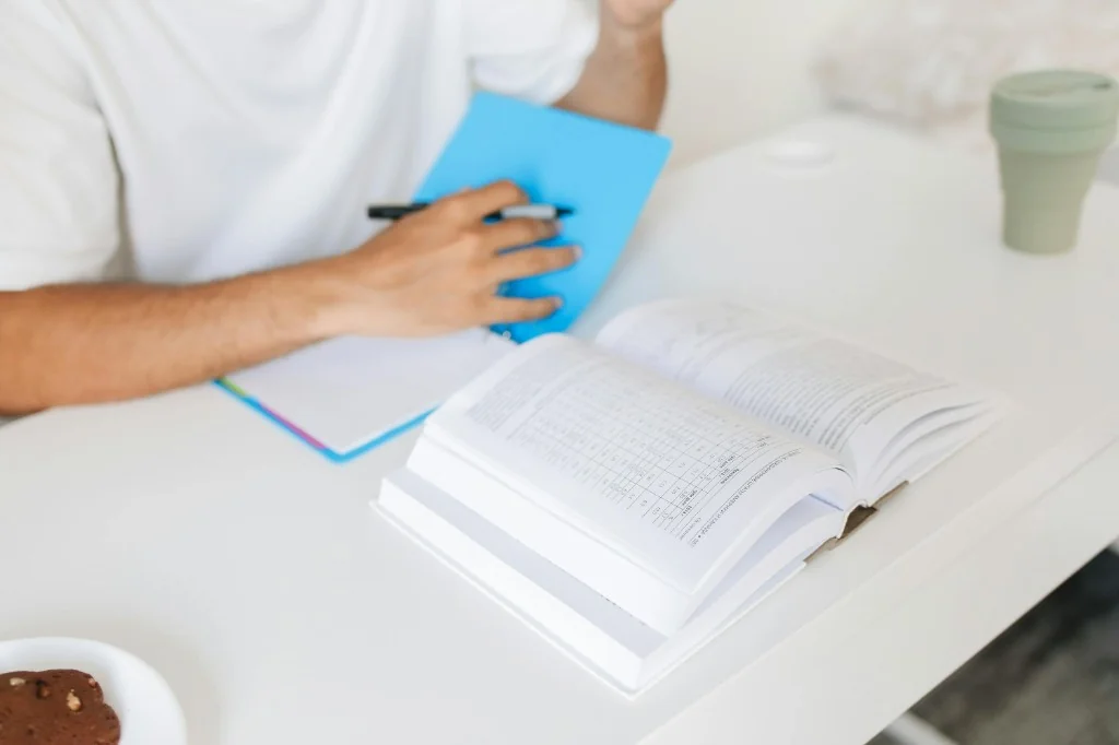 Student studying with a notebook and textbook